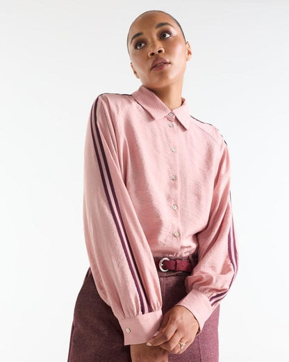 Model wearing the Anieka pink blouse with contrasting piping along the sleeves