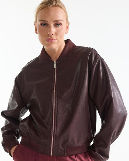 Model wearing the Bian wine red leather look bomber jacket zipped closed