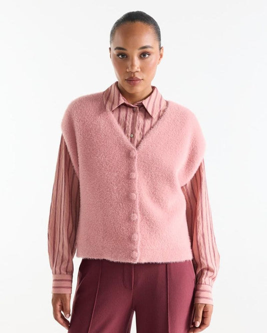 Model wearing the Chelsie pink fluffy sweater vest layered over a striped blouse